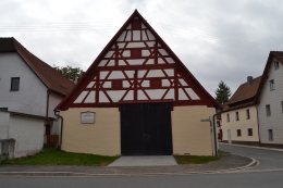 Der Giebel zur Hauptstrasse, B2
Der Stadel hatte eine Tenne und 2 Bahrnteile. Jetzt ein großer Raum, die Deckenbalken durch zwei Unterzüge mit je 4 mächtigen Säulen gestützt. 